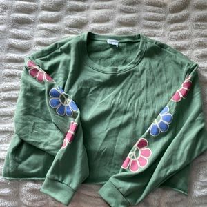 Size M green sweatshirt with flower design on arms. From vanilla sky